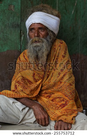 MATHURA,INDIA - March 28,2013 : Unidentified old Indian man sits in front of a door during Holi Festival time in Mathura,India.