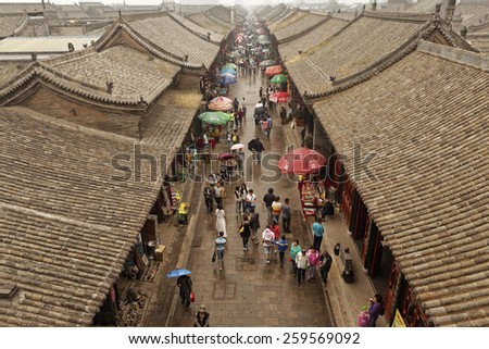 PINGYAO,CHINA - September 20,2013 : Unidentified chinese people and tourists walk and shop on the ancient streets of Pingyao,China.