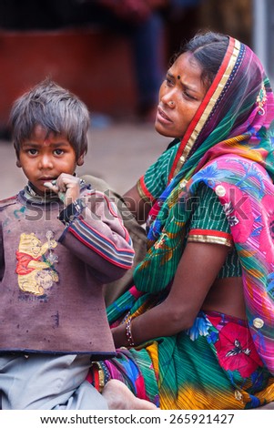 AGRA,INDIA - March 27,2013 : Unidentified traditionally dressed mother and her son sit on the streets of Agra City india.