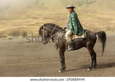 BROMO TENNGER,JAVA,INDONESIA - May 27,2015 : Unidentified horse rider rides the horse near Mt.Bromo and Mt Semeru in early morning.
