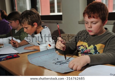 Frankfurt, Germany - November 11, 2014 - German pupils learning chinese calligraphy and origami with chinese exchange teacher