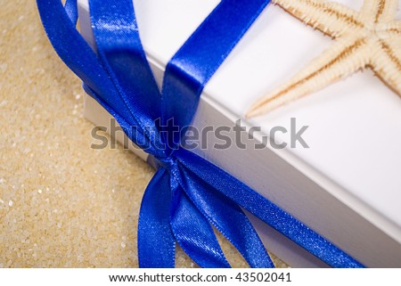 photo of starfish and gift box on the sand