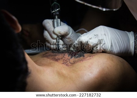 tattooer showing process of making a tattoo. Tattoo design in pattern