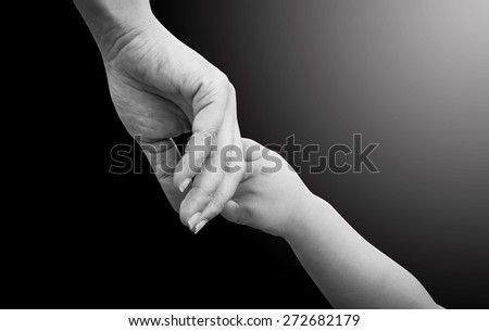 Black and white hands of mother and child.