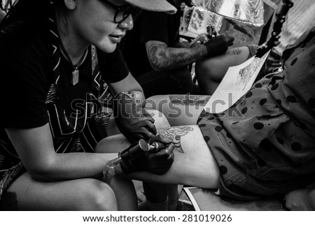 Showing process of making a tattoo. woman tattoo artist