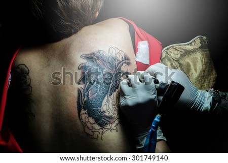 Women are tattooing koi. woman artist.