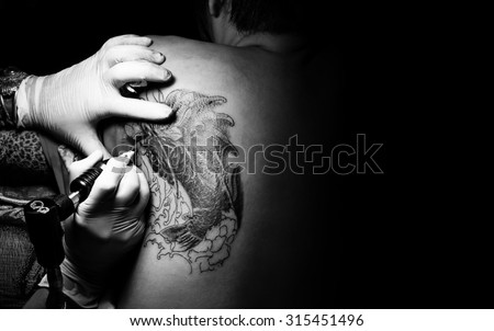 Showing process of making a tattoo by professional artist. art tattooist lifestyle processing machine studio body designs gun concept action ink skin woman female white black people.
