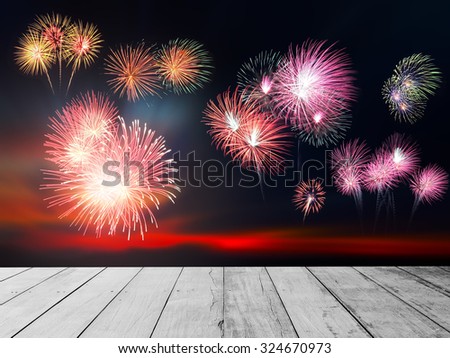 Beautiful firework display for celebration. Old wood floor background. Sunset background. Stage for watching a fireworks display.
