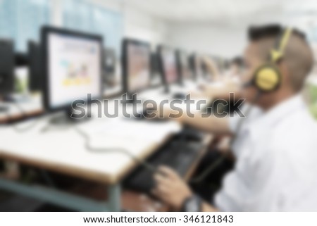 Abstract blur background boy student use computer in school computer room. Network communication for education. Student using computer in learning and teaching