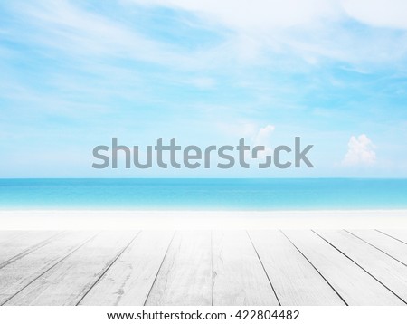 Wood floor with white blue surfing wave background. Blue water and sky bright. Nature wallpaper blur of sea daytime. Focus to wooden in the foreground. Timber pattern texture stage.