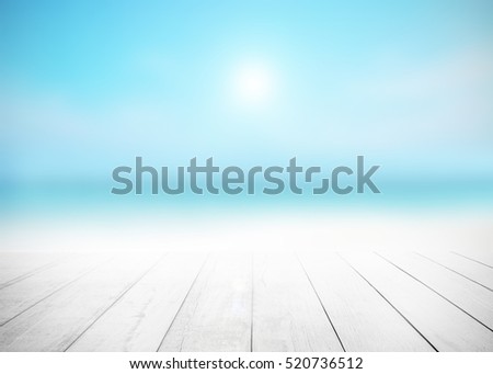 Wood floor with white surfing wave background. Blue cool water and sky bright rays light. Nature wallpaper blur of sea daytime. Focus to wooden in the foreground. Timber pattern texture stage.