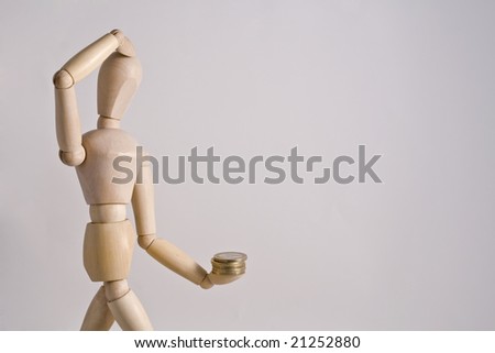 A pensive  wood toy with money in one of his hands