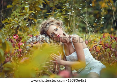 Beautiful fairy girl with golden cage in a forest
