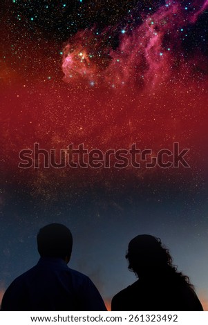 Silhouettes of couple looking at stars. Starry night sky with colorful galaxies, astronomical background with place for your text.Elements of this image furnished by NASA.