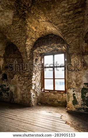 Old window of an abandoned house. Inside the old castle