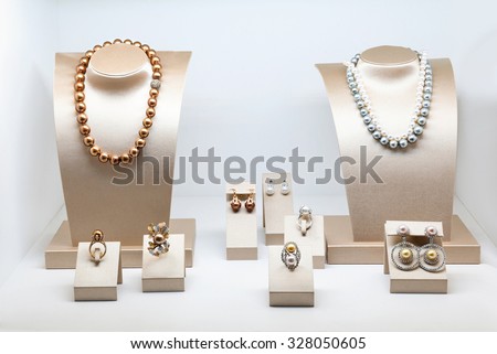 Set of luxury jewelry with precious gems and diamonds. Necklaces made of natural pearls on a stands. Women accessories