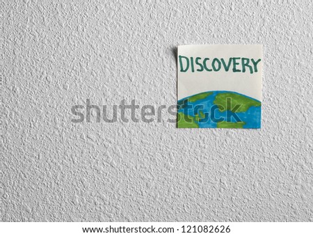 Sticker with a design of the globe and the word \'Discovery\' on white wall