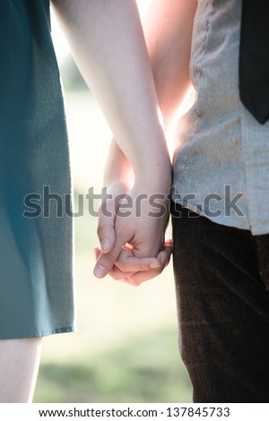 Unrecognizable couple holding hands in a close up view