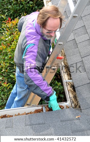 Man cleaning gutters on ladder