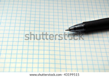 Blank grid paper with pen resting on top. Copy space on the left