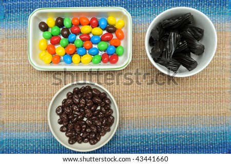 A selection of chocolate colorful beans, black Australian licorice, or chocolate covered raisins.
