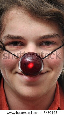 Young white male Caucasian teenager with a strap on reindeer glowing red nose ball.