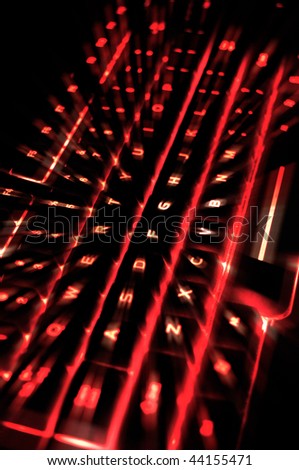 A backlit illuminated computer keyboard with red for the color and a zoom effect.