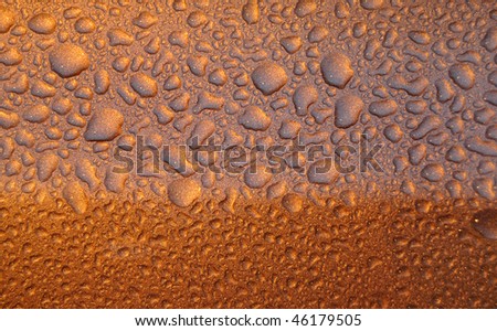 Water droplets on gold sparkle textured surface. This water drops texture was originally on a shiny car.