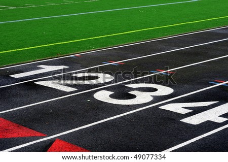 Numbered lanes on a mile running fitness athletic black track.