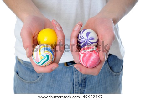 Hand holding a set of four round bouncy rubber balls with colorful designs on them