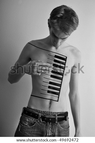 Young male playing a piano on his body. Black and white creative expressive portrait