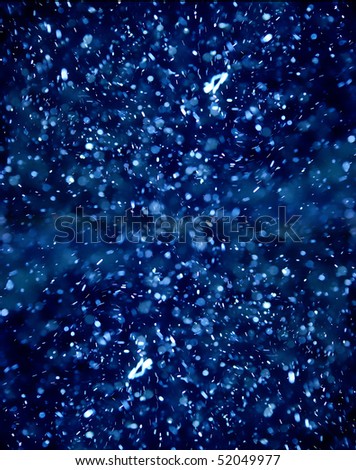 Abstract image of illuminated bubbles flying around that looks like snow.