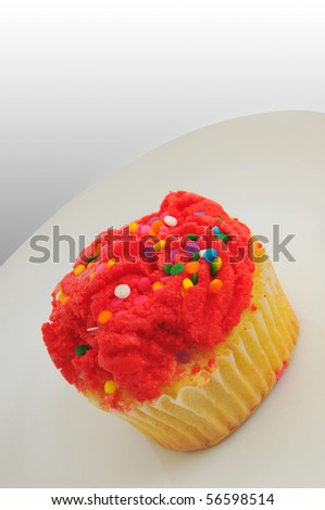 Single red cupcake on a small white dish with white background