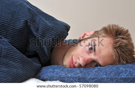 Young Caucasian teenage adult male sleeping on his pillow with his eyes closed.