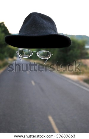 An invisible man walking down the road wearing only a hat and a pair of glasses.