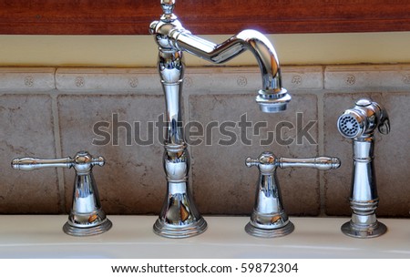 Closeup of a kitchen sink faucet and handles