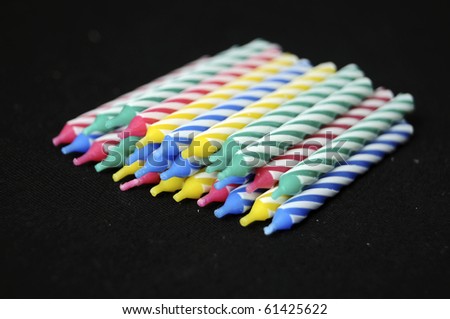 A bunch of unlit new birthday candles isolated on black background