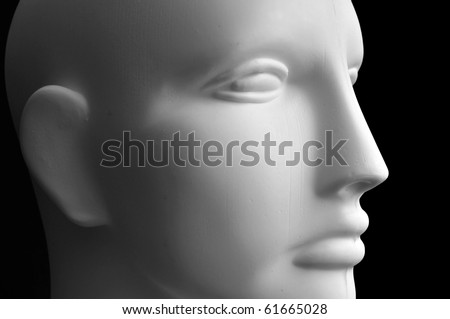 Front view of a mannequin dummy head isolated on a black background.