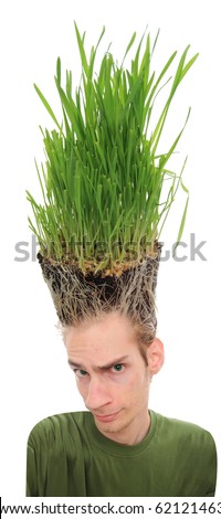 A young man looking upward at the grass growing from the roots on top of his head. This concept can apply to environmentalists, farmers, agriculture, landscapists, gardeners, and crazy haircuts. - stock photo