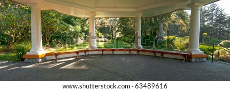A large beautiful gazebo with study pillars supporting it on a cement pad. Inside panorama of the interior.