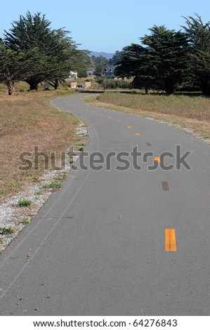 A narrow bike path that looks just like a asphalt street