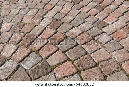 A red cobblestone curve with square bricks. Ground work.