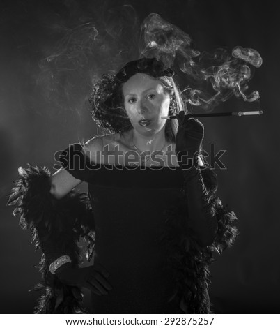 Black and White Portrait of Glamorous Woman Smoking Cigarette and Dressed in Vintage Clothing, Standing with Hand on Hip, Waist Up Portrait in 1940s Film Noir Style