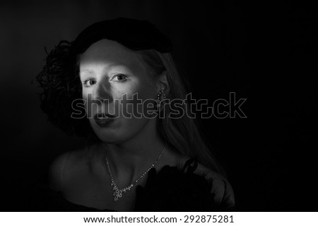 Black and White Head and Shoulders Portrait of Glamorous Woman Dressed in Vintage 1940s Clothing with Eyes Illuminated Dramatically, in Dark Film Noir Style
