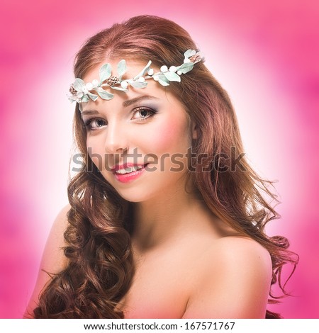 Beauty portrait of a girl with long hair on pink background