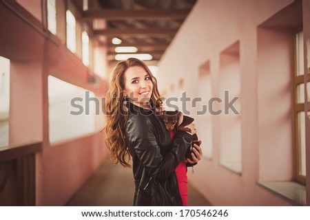 Beautiful red-haired girl in a leather jacket in the urban landscape / Young fashionable woman