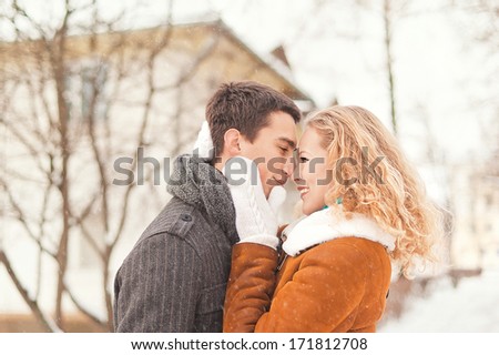 Young couple  in love having fun in winter forest walks and gentle hugs