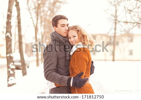 Young couple  in love having fun in winter forest walks and gentle hugs