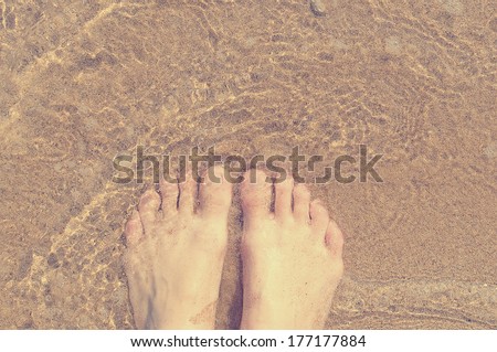 Feet in the sea. Relax on the beach. Beach vacation.