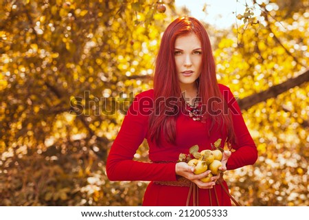 Beautiful woman in the garden with green apples.
